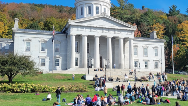State house in fall with people on lawn